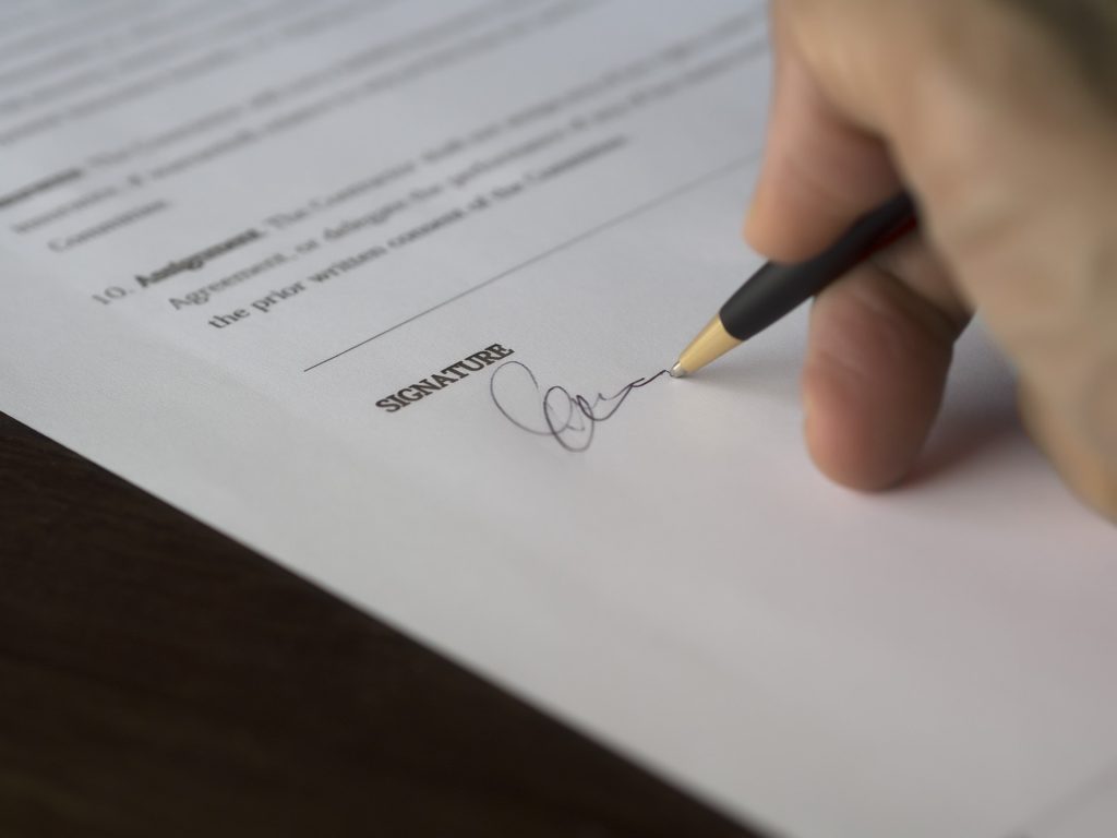 Image of someone signing a compliant pursuant to the Federal Tort Claims Act.